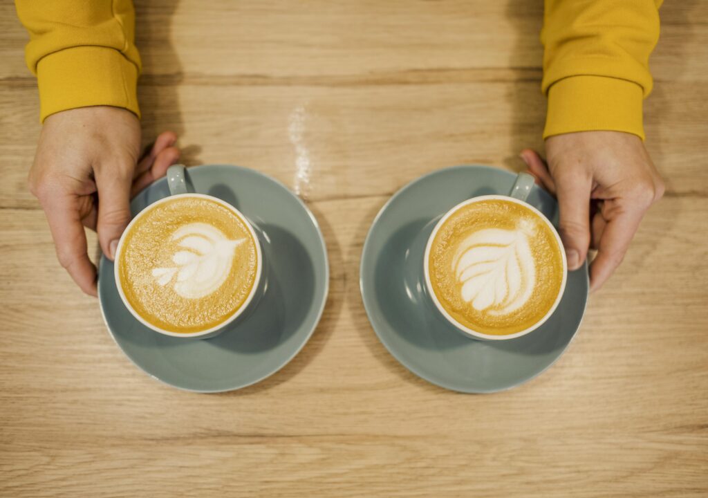Mãos segurando chícaras de Café com Leite vs. Café Pingado, Café do Norte explica essa dúvida manauara.